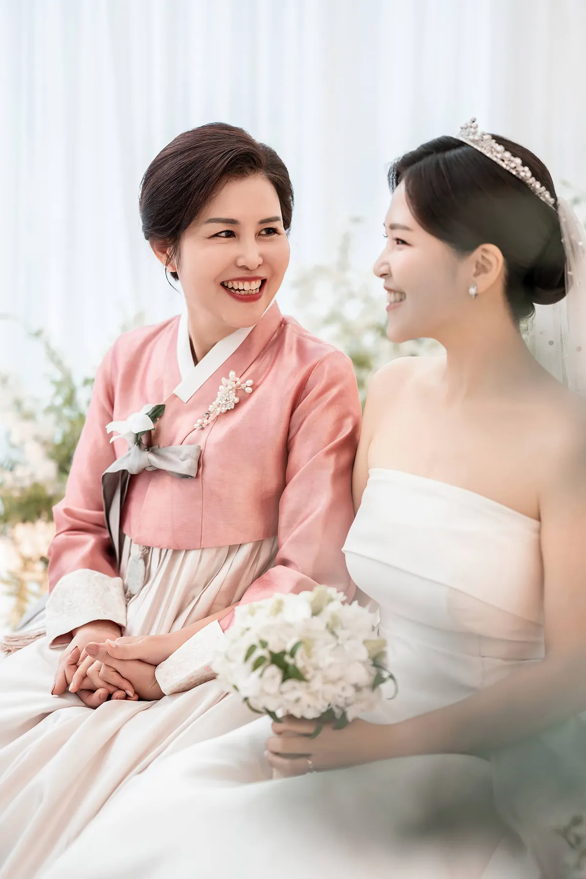 신부와 어머니가 서로 바라보며 웃는 순간을 담은 교회웨딩 가족 스냅