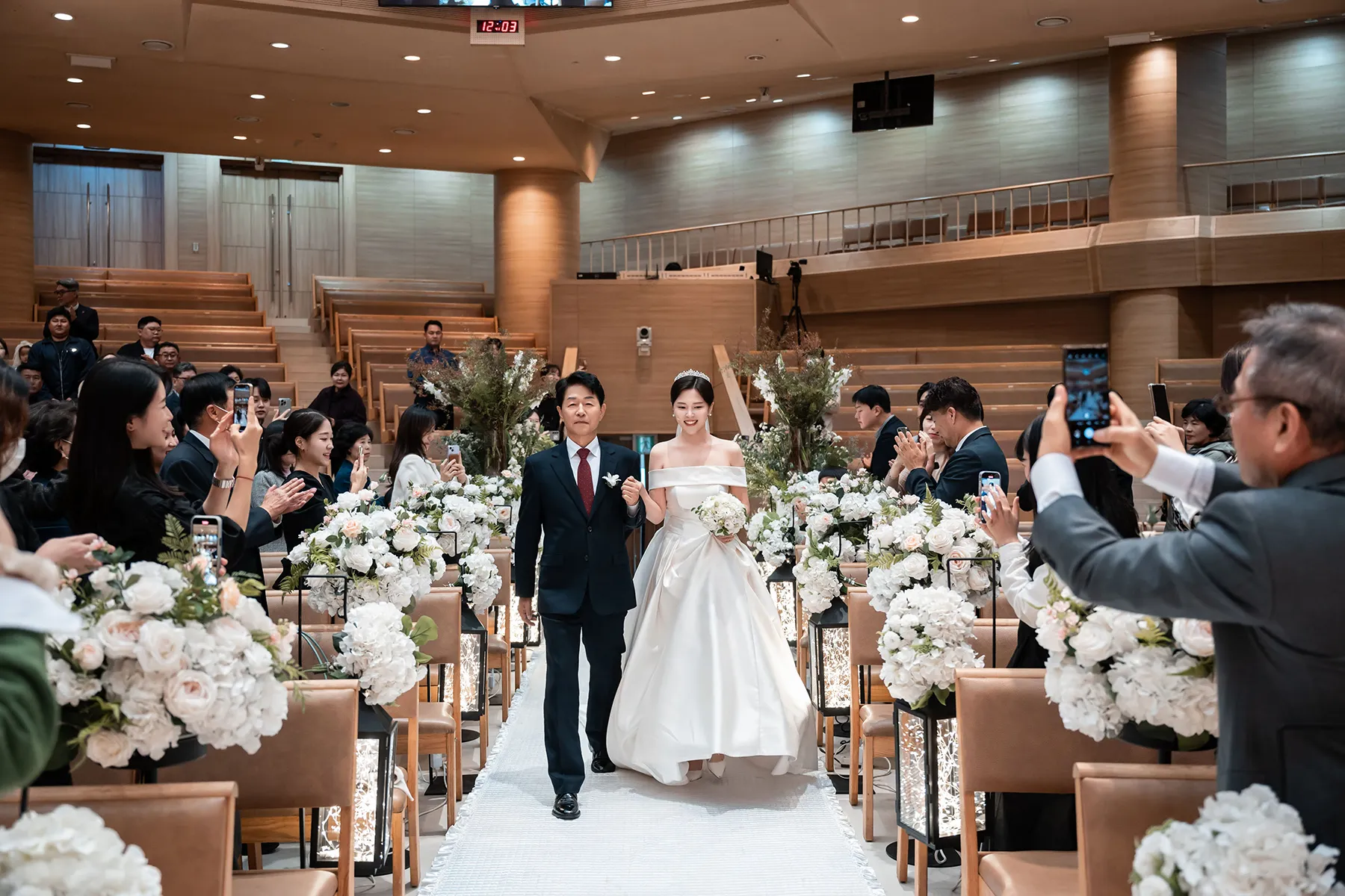하객 사이를 함께 걸어 나오는 신부입장을 기록한 신촌성결교회 본식스냅