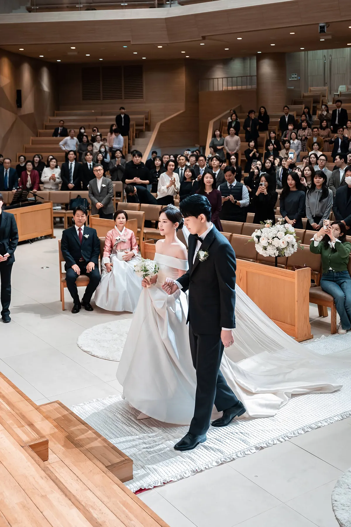 하객의 축하를 받으며 버진로드를 걷는 신랑신부의 교회웨딩 본식스냅