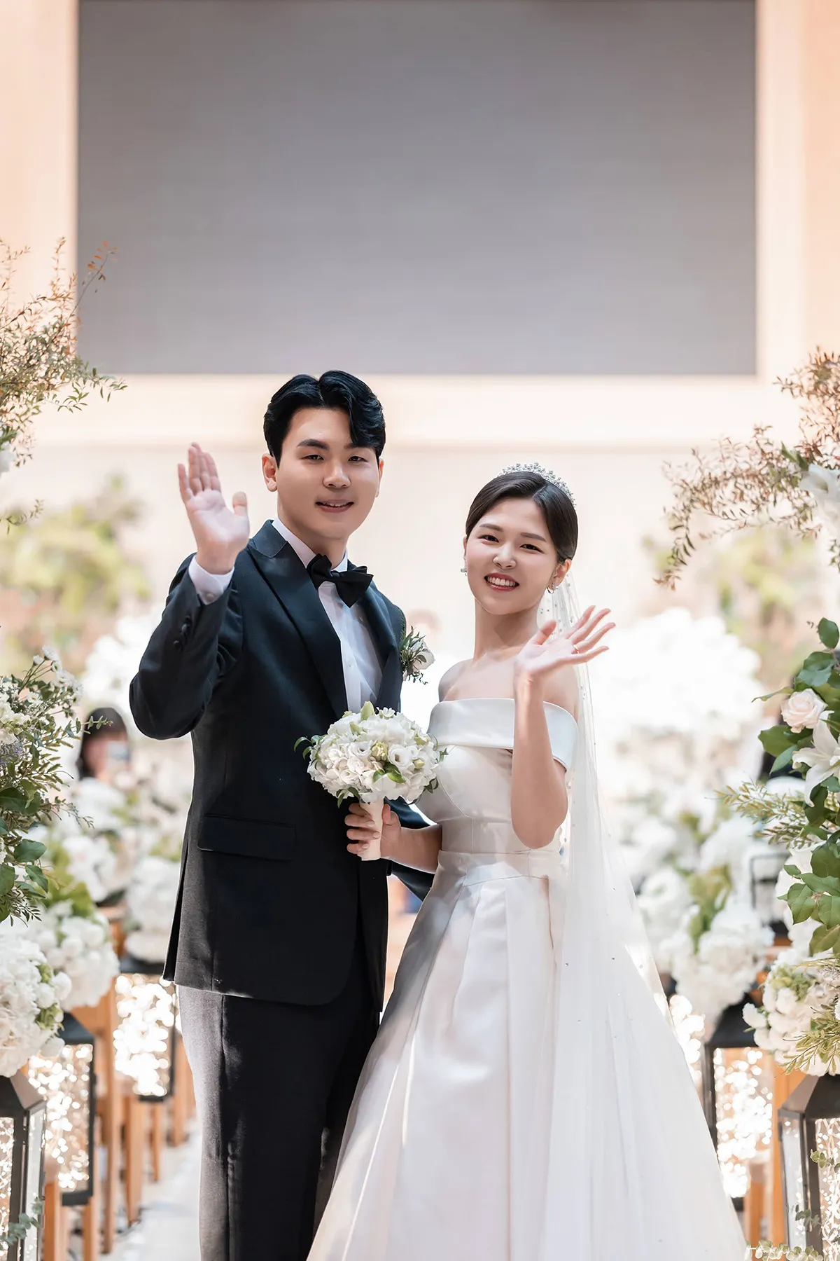 예배당 꽃장식을 배경으로 부케를 든 신랑신부의 신촌성결교회 웨딩스냅